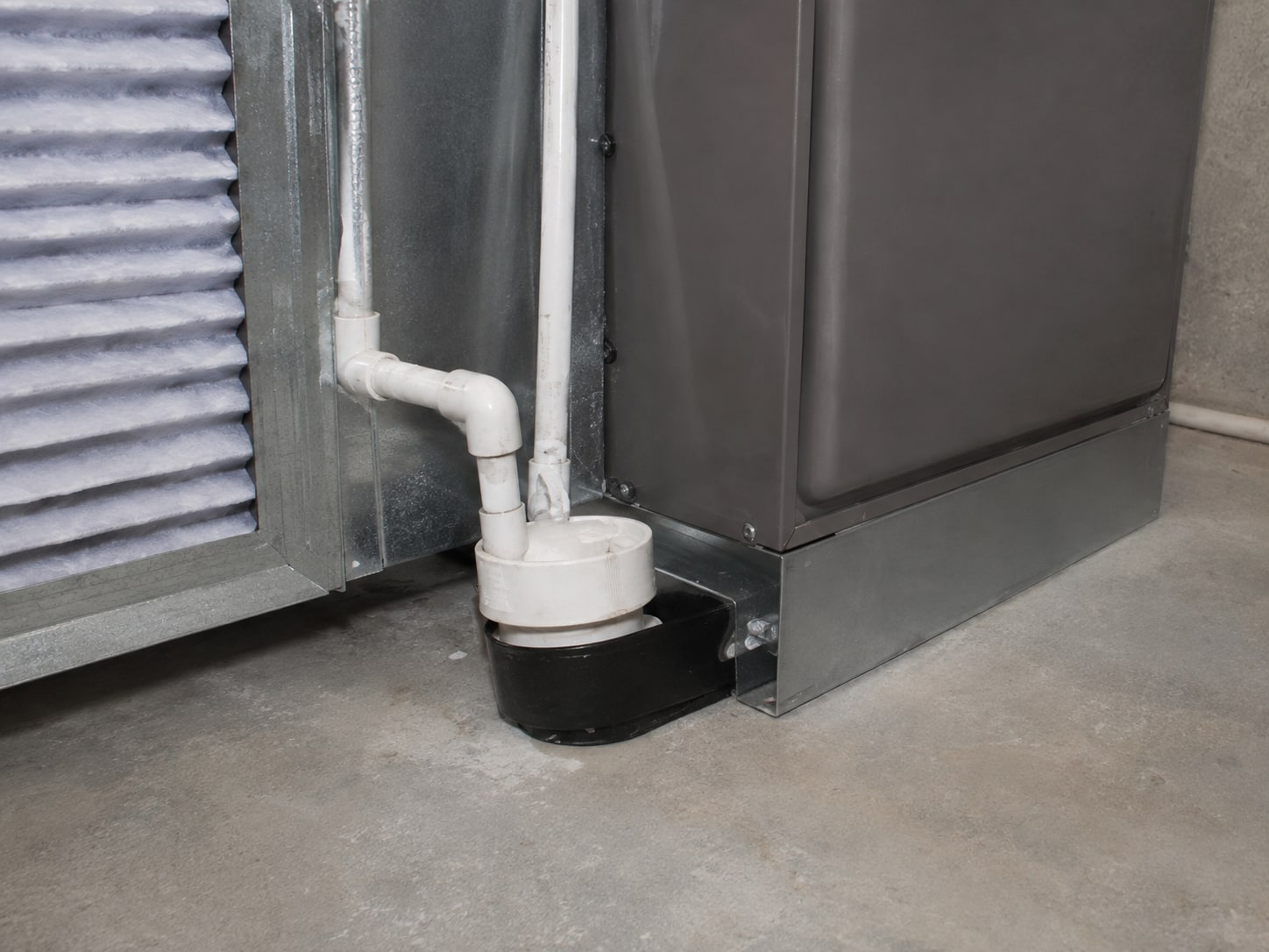 System A cabinet drain connection and surrounding surface.